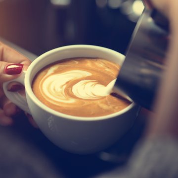 best type coffee maker woman pours milk in cup of coffee